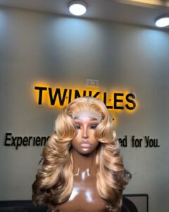18-inch Super Double Drawn Dirty Blonde Chinese Wavy human hair wig with brown lowlights and a 5x5 Swiss lace closure.