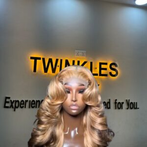 18-inch Super Double Drawn Dirty Blonde Chinese Wavy human hair wig with brown lowlights and a 5x5 Swiss lace closure.