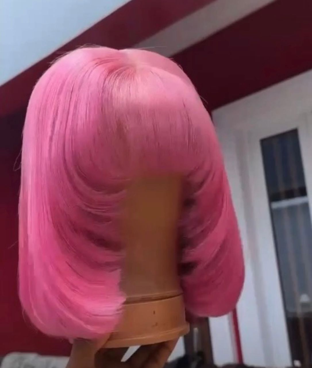 12-inch Super Double Drawn baby pink Vietnamese bone straight human hair wig styled with full fringe bangs and heavily curved, face-framing layered edges.
