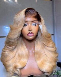 22-inch Super Double Drawn Dark Root Blonde Vietnam Bounce Virgin hair wig with a 5x5 Swiss lace closure and voluminous layered curls.