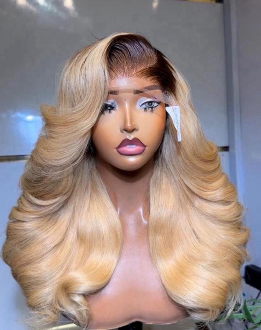 22-inch Super Double Drawn Dark Root Blonde Vietnam Bounce Virgin hair wig with a 5x5 Swiss lace closure and voluminous layered curls.