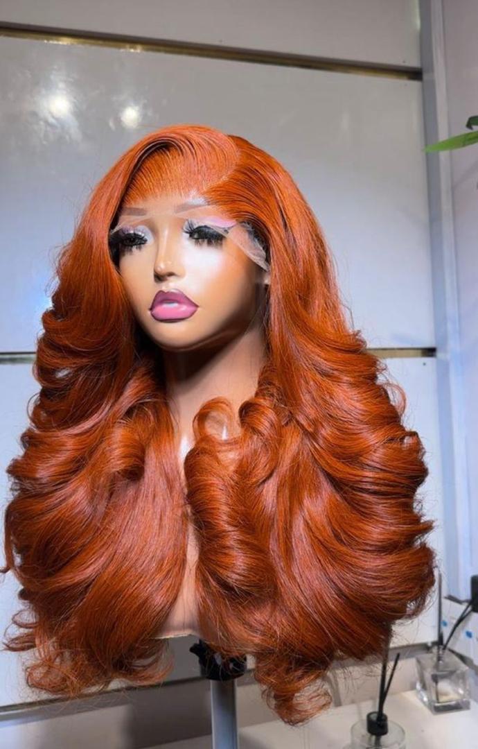 22-inch layered Cajun Ginger Vietnam Bounce Virgin human hair wig with a 5x5 lace closure styled in voluminous barrel curls.