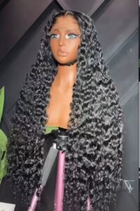 32-inch premium raw deep wave human hair wig styled with ultra-defined, high-volume wet look curls on a 5x5 Swiss lace closure.